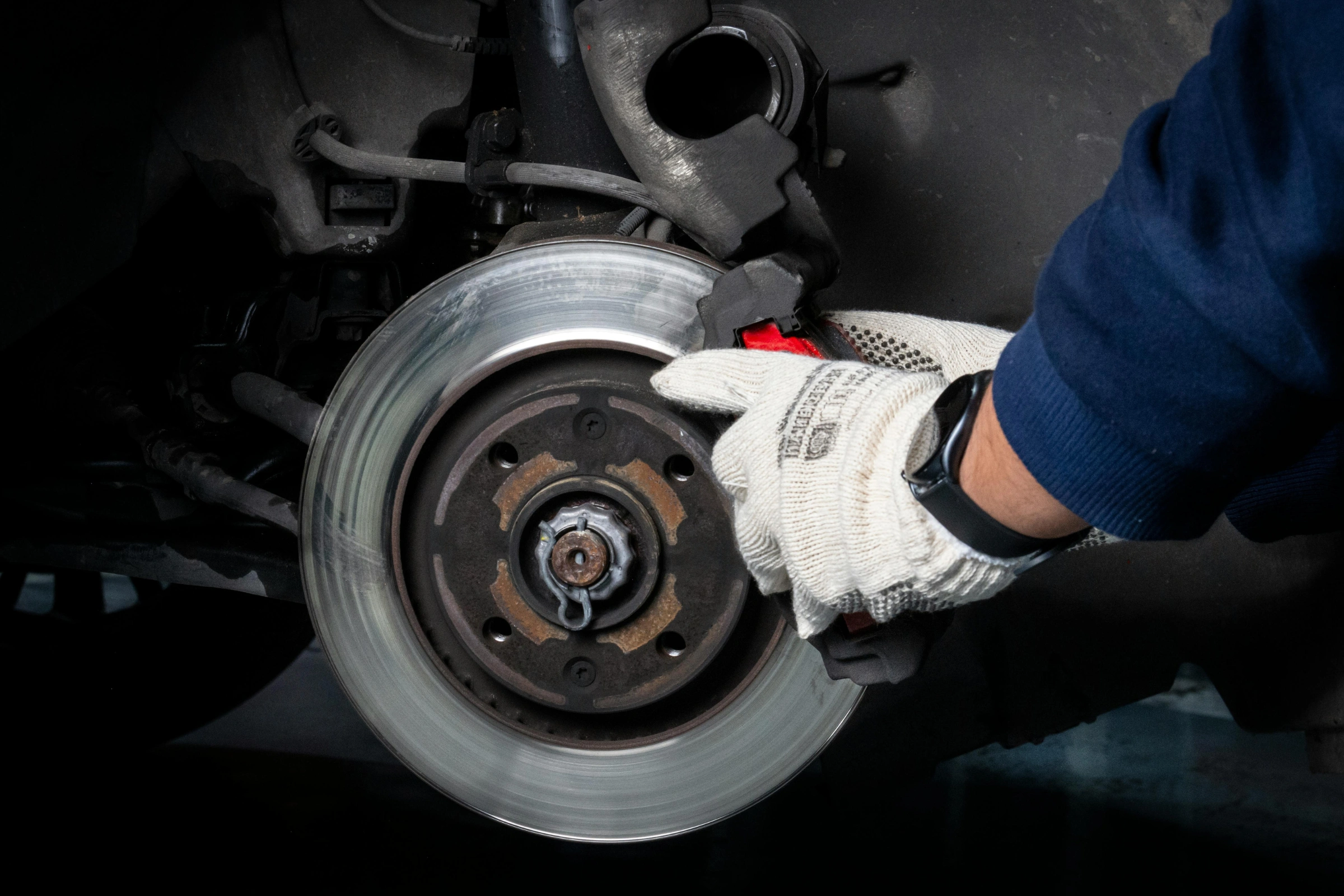 Certified technician performing brake repair on a vehicle at Heartland Tire & Auto Centers in Brooklyn Park, MN