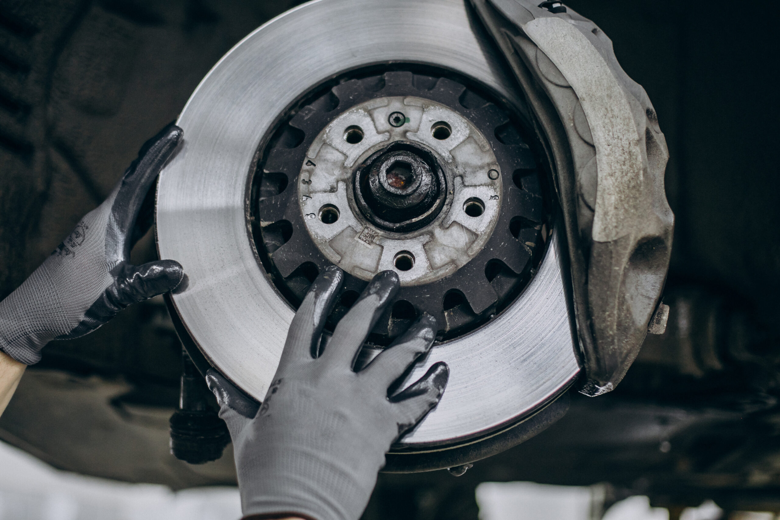 Auto technician replacing a vehicle brake rotor during professional brake repair and brake service